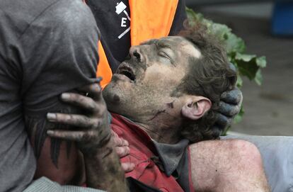 Un hombre es rescatado con vidade los escombros de un edificio derruido por el terremoto en la localidad de Christchurch.