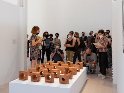 Nuria Güell delante de las piezas de barro con los impactos de bala de la obra 'El síndrome de Sherwood 2', en Fabra i Coats.