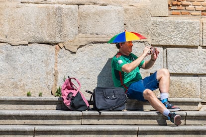 Un hombre se protege del calor con un "sombrero sombrila" este domingo en Toledo, donde se ha activado el aviso naranja por altas temperaturas. 
