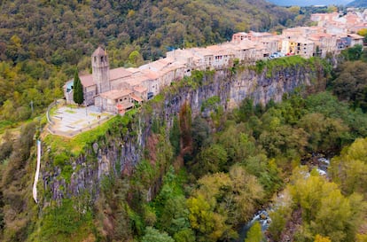 Castellfollit de la Roca (Girona). Los franceses derribaron el castillo en 1691, pero el pueblo sigue en lo alto de una roca espeluznante, infernal, surgida de las entrañas de la tierra hace 200.000 años, cuando la Zona Volcánica de La Garrotxa estaba en plena ebullición. Dos coladas de lava superpuestas formaron este acantilado de 50 metros de altura: un precipicio de columnas basálticas que semeja un órgano de viento de gigantes. Pueblo y risco multiplican por dos su belleza al espejarse en las aguas del río Fluvià. Así se ven desde la pasarela-mirador de Castellfollit de la Roca. No tiene pérdida.