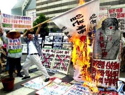 Un surcoreano quema una bandera japonesa y un cartel del primer ministro Koizumi en una protesta en Seúl.