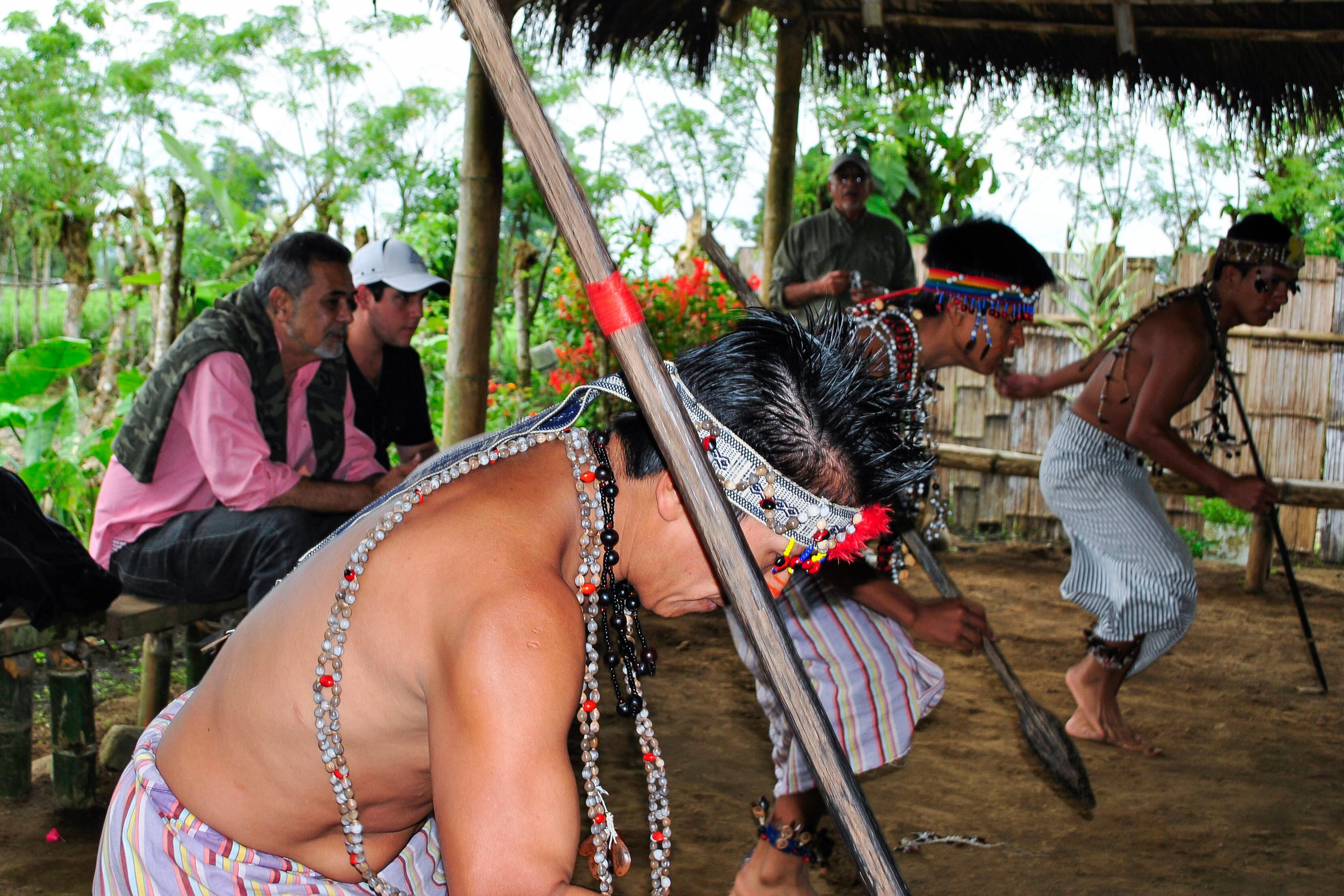 Un grupo de turistas contempla una danza tradicional en un poblado de indios shuar.