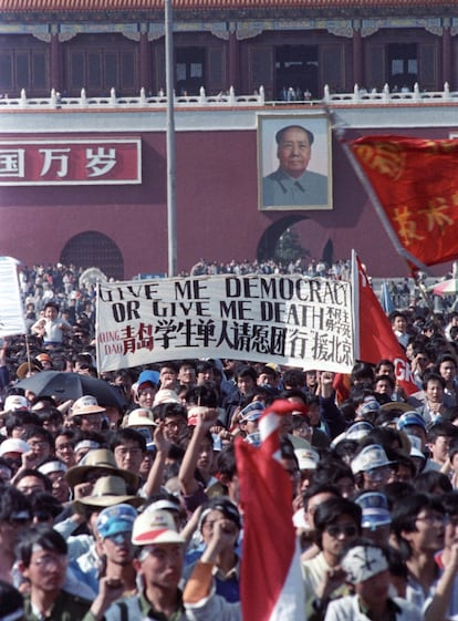 En mediados de abril de 1989 decenas de miles de estudiantes, obreros e intelectuales, iniciaron una serie de protestas pacíficas en Pekín, que se extenderían a otras ciudadades chinas, dando paso en la historia al denominado Movimiento Prodemocrático de 1989. En la foto, una multitud de estudiantes portan un cartel en el que se puede leer "Dame democracia o dame la muerte", durante una manifestación en la Plaza de Tiananmen en Pekín (China), el 14 de mayo de 1989. Al fondo, la entrada a la Ciudad Prohibida presidida por un retrato del difunto Presidente Mao.