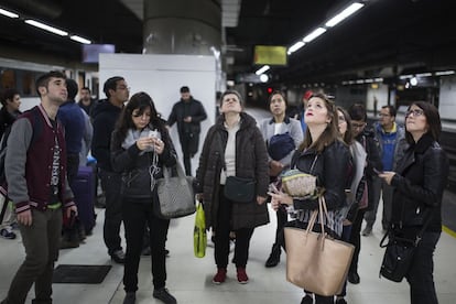 Viatgers a la estación de Sants, consultando los paneles informativos para saber cuando pasa el tren.