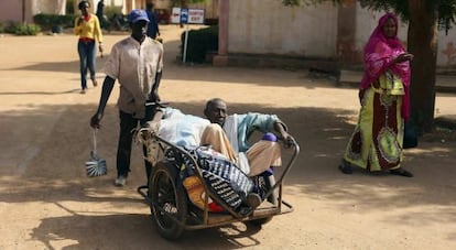 Un hombre es transportado en un carrito al hospital Nianakoro Fomba en Segou.