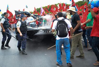 Policial usa spray de pimenta para dispersar sem-terra durante protesto.