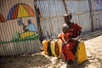 Dos niñas somalíes sobre bidones vacíos de agua en el campo de refugiados de Tawakal, a las afueras de Mogadishu, en Somalia.