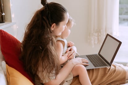 Una madre teletrabaja, mientras cuida a su bebé.