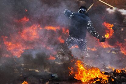 Un manifestante rodeado por las llamas se prepara para lanzar un cóctel molotov en el centro de la capital de Ucrania.