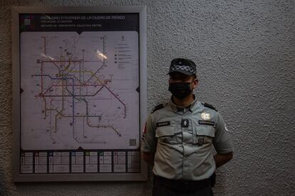Un elemento de la Guardia Nacional junto a un mapa del sistema de Movilidad Integrada de la Ciudad de México. El sistema, que incorpora varios medios de transporte, está conformado por autobuses, bicicletas, líneas de Metro, tren ligero, Metrobús y Cablebús.
