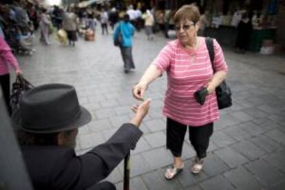 Un pobre pide limosna junto al mercado de Yehuda en Jerusalén, Israel. EFE/Archivo