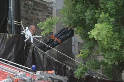 Miembros de la policía que investiga el caso sacan uno de los cuerpos encontrados de la casa de la familia desaparecida en Nantes.