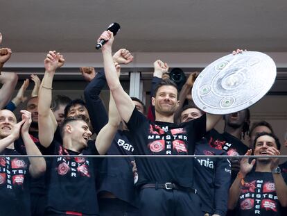 Xabi Alonso micrófono en manos se dirige a la hinchada del Leverkusen rodeado de sus jugadores, en el estadio, el domingo.