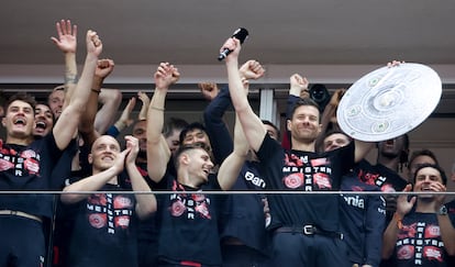 Xabi Alonso micrófono en manos se dirige a la hinchada del Leverkusen rodeado de sus jugadores, en el estadio, el domingo.