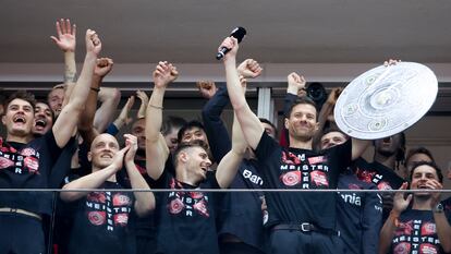 Xabi Alonso micrófono en manos se dirige a la hinchada del Leverkusen rodeado de sus jugadores, en el estadio, el domingo.