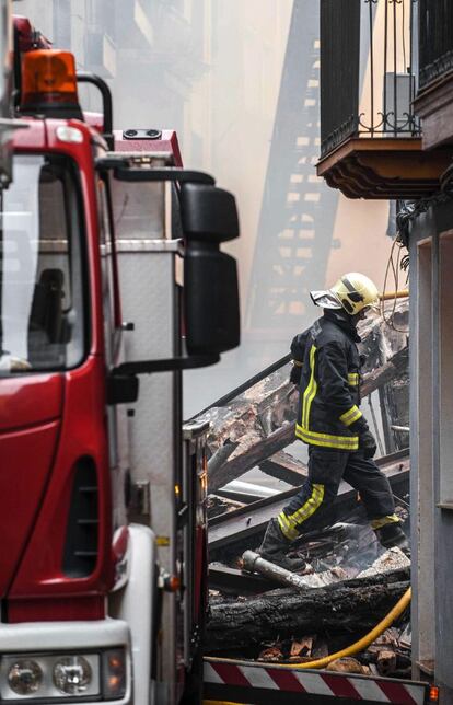 En la foto, un bombero sobre los escombros de uno de los edificios derrumbados. 