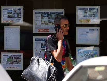 Un hombre pasa delante de una inmobiliaria de Sevilla, en una imagen de archivo.