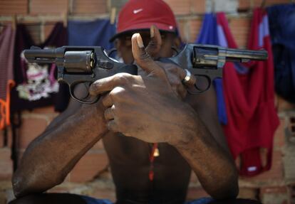 'Pilintra' un joven de 26 años que forma parte de una pandilla de drogas posa con sus armas en Salvador de Bahía.