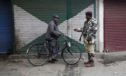 Soldado paramilitar indiano checa a identidade de um civil durante toque de recolher em novembro de 2014 em Srinagar (Índia).