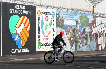 Un ciclista pasa junto a un mural pintado en apoyo a la independencia de Cataluña, en Belfast (Irlanda del Norte).