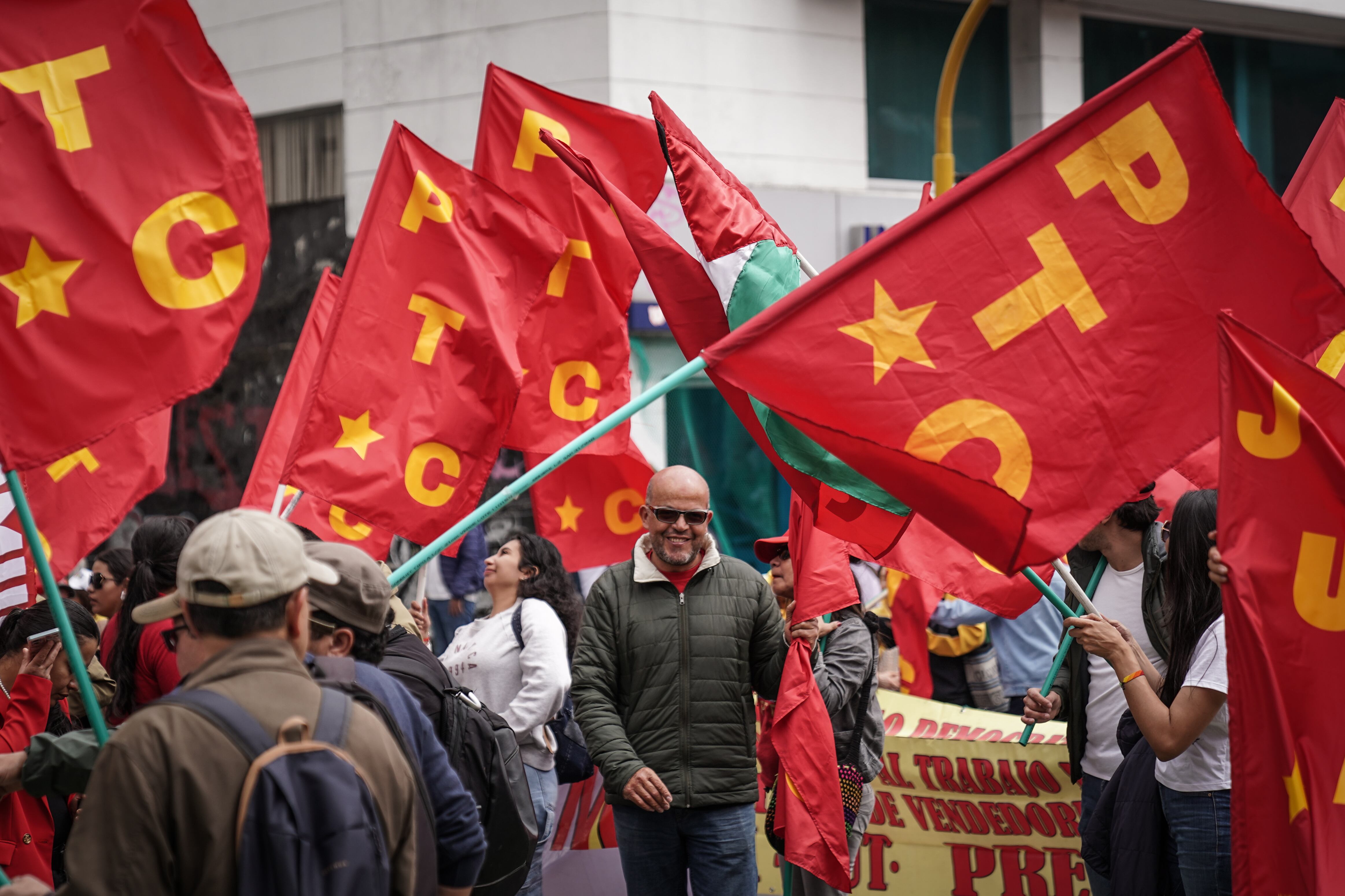 Un grupo de personas con banderas del Partido del Trabajo recorren las calles de Bogotá, este miércoles.
