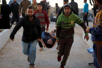Unos hombres transportan a un herido en una camilla en Dael el viernes después de un bombardeo ruso.