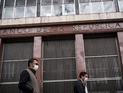 Hombres caminan al frente del edificio del Banco de la República, en Bogotá, el 28 de julio de 2022.