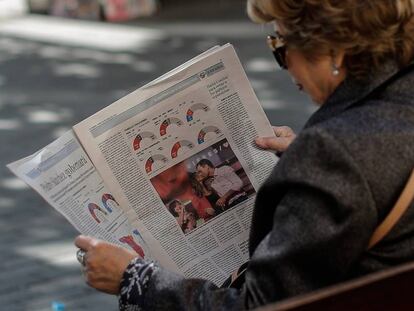 Una mujer lee el periódico.