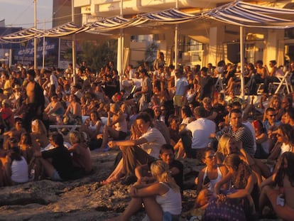 Turistas en Café del Mar en la Bahía de San Antonio de Ibiza, esperando la puesta del Sol.