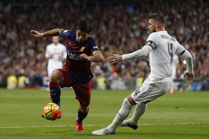 Luis Suárez protege el balón ante Sergio Ramos. El central forzó para jugar el clásico, se infiltró de nuevo y después del partido aseguró que ahora parará para intentar recuperarse sin pasar por el quirófano.