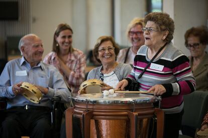 Una participant al taller de música per a malalts d'Alzheimer fa sonar el tambó. 