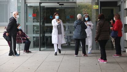 Varias trabajadoras sanitarias hablan con pacientes que esperan en la puerta de un Centro de Salud en Coslada, Madrid (España), el pasado noviembre.