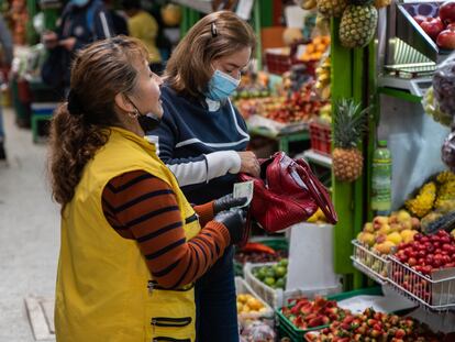 Una mujer compra frutas y verduras en la plaza de mercado Paloquemao en Bogotá, en junio de 2022.