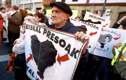 Un asistente a la manifestación sostiene un cartel con le lema 'Euska presoak, etxera' reivindicando el acercamiento de los presos de Eta al País Vasco.