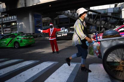 Un trabajador de un centro comercial vestido de Santa Claus dirige el tráfico en Bangkok (Tailandia), el 25 de diciembre de 2018. 