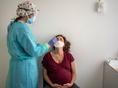 Una sanitaria del hospital Clínico San Carlos toma una muestra a una embarazada para realizar una PCR