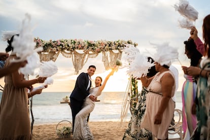 Una pareja de recién casados celebra su unión en una ceremonia a pie de playa.