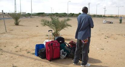 Um imigrante africano espera um meio de transporte depois de ser libertado no Neguev, no sul de Israel.