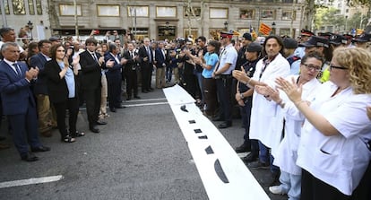 Fotografía facilitada por la Generalitat de Cataluña, del presidente catalán, Carles Puigdemont (tercero por la izquierda), y la alcaldesa de Barcelona, Ada Colau (segunda por la izquierda), y los demás miembros del Govern, junto a los 75 representantes de cuerpos de seguridad, emergencias y de entidades vecinales y ciudadanas que encabezarán la manifestación contra el terrorismo bajo el lema No tinc por (No tengo miedo). 