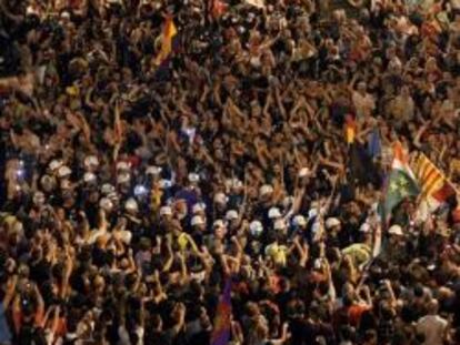 Miles de personas acompañan a los mineros de la "marcha negra", la mayoría vestidos de negro y con las luces de sus cascos encendidas, a su llegada a la Puerta del Sol, en Madrid, el 10 de julio de 2012