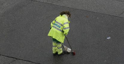 Una trabajadora barre una calle de Madrid.