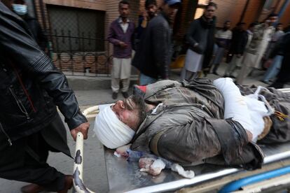 Trabajadores y voluntarios transportan a una víctima de la explosión ocurrida en una mezquita de Peshawar, este lunes 30 de enero.
