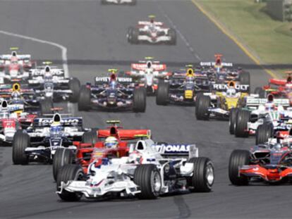 Lewis Hamilton, a la izquierda, toma la primera curva de la carrera. A la derecha, por delante de Raikkonen, el Renault de Alonso.