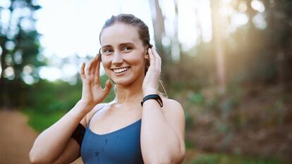 Una chica colocándose los auriculares de conducción ósea.