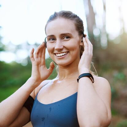 Una chica colocándose los auriculares de conducción ósea.