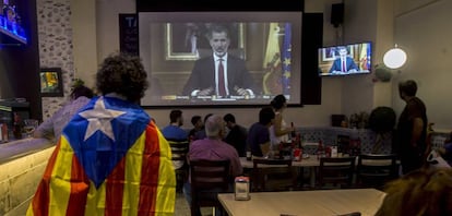 Varias personas miran el discurso del Rey Felipe VI, el 3 de octubre.