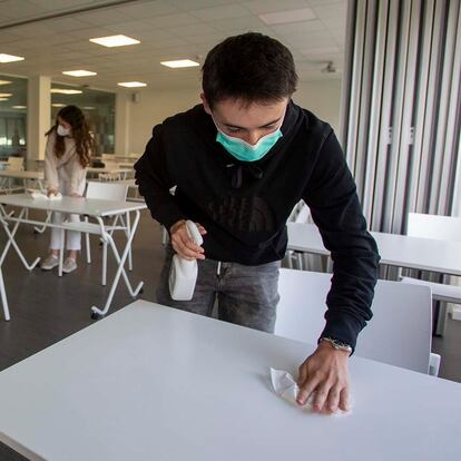 Estudiantes del liceo Axular, en San Sebastián, desinfectan sus mesas de estudio tras finalizar el examen.