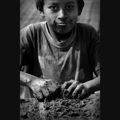 Niño amoldando el barro en la gabera. Obtendrá cuatro piezas que pesan alrededor de 15 kg. Ladrillera de Huachipa (Lima).