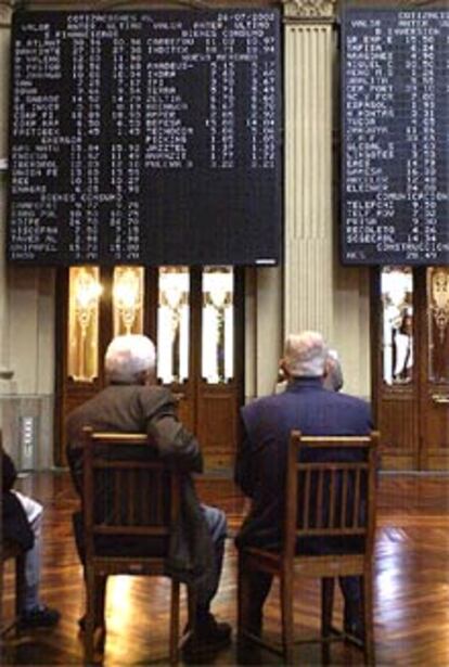Dos inversores vigilan el desarrollo de la jornada de hoy en la Bolsa de Madrid.
