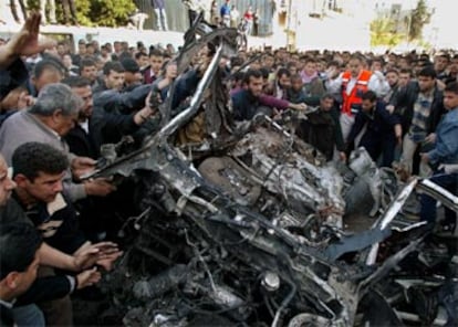 La multitud que salió a las calles de Gaza tras el atentado da la vuelta al coche carbonizado.